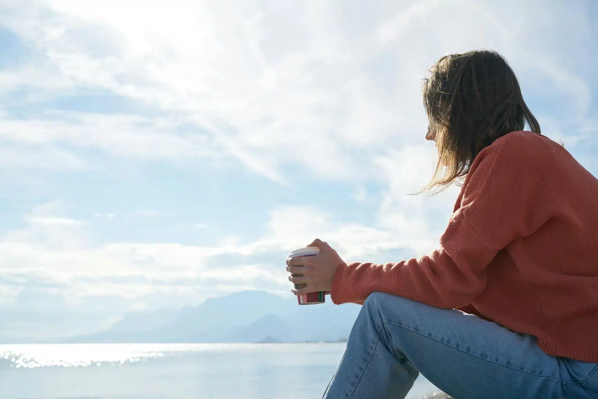 A woman sitting reflecting on the beach