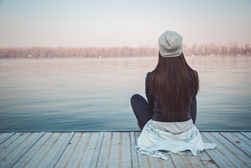A girl looking at the lake wondering about how self-judgement impacts relapse
