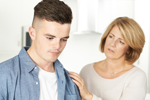 A concerned mother noticing warning signs of addiction in her child.